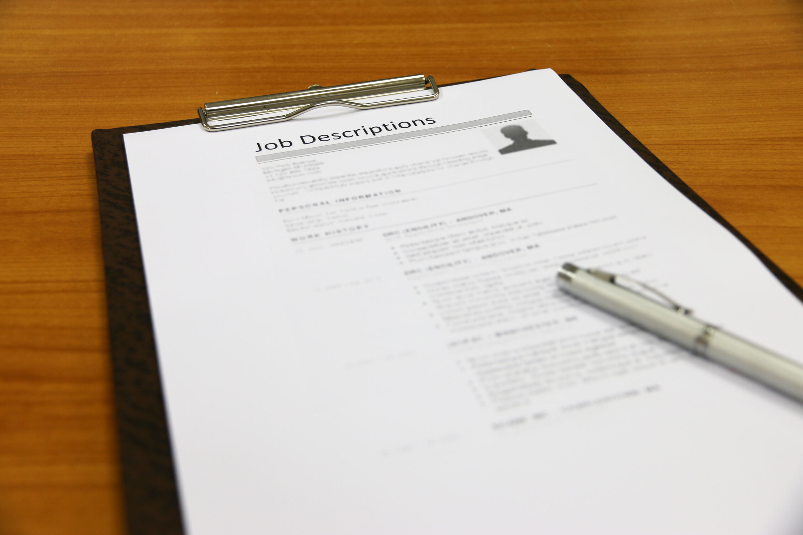 A copy of job description on a table with a pen.